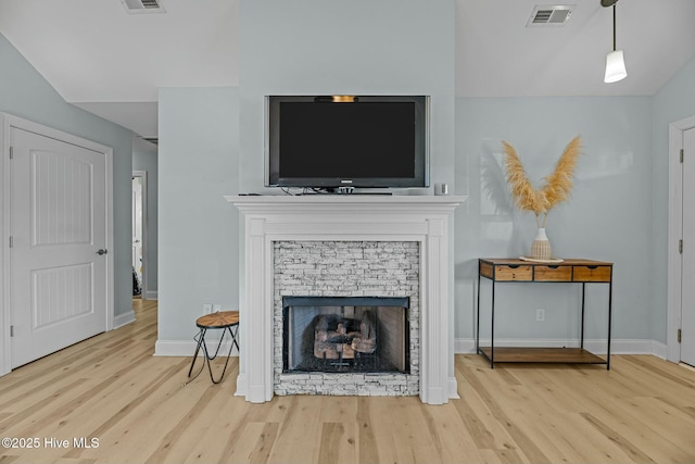 living room featuring light hardwood / wood-style flooring, lofted ceiling, and a fireplace