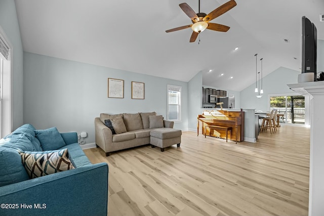 living room with ceiling fan, light wood-type flooring, and lofted ceiling