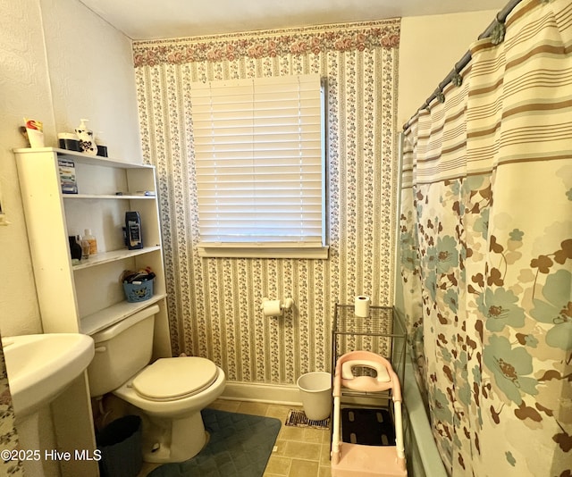 bathroom featuring curtained shower, tile patterned floors, and toilet