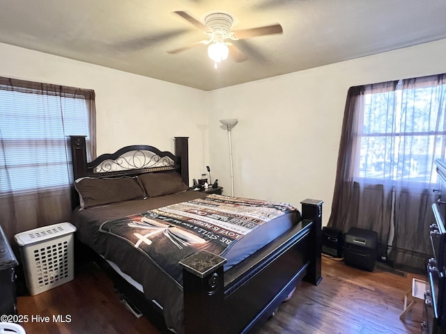 bedroom with dark hardwood / wood-style floors and ceiling fan