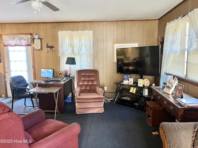 carpeted living room featuring wooden walls, ornamental molding, and ceiling fan