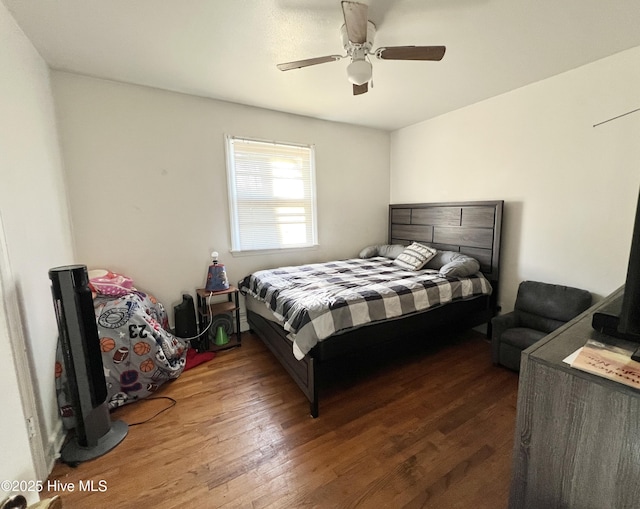 bedroom with dark hardwood / wood-style flooring and ceiling fan