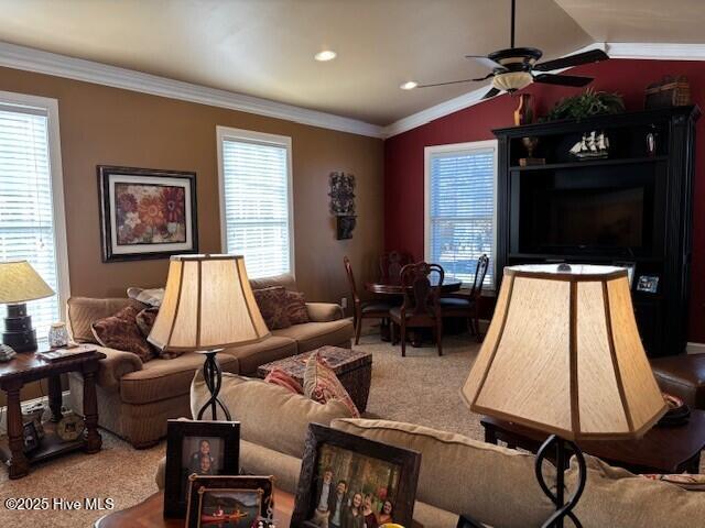 carpeted living room featuring crown molding, ceiling fan, and vaulted ceiling