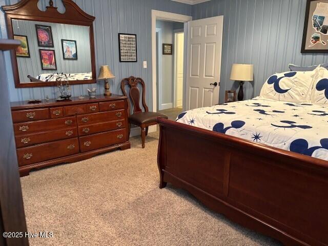 bedroom with light carpet and crown molding