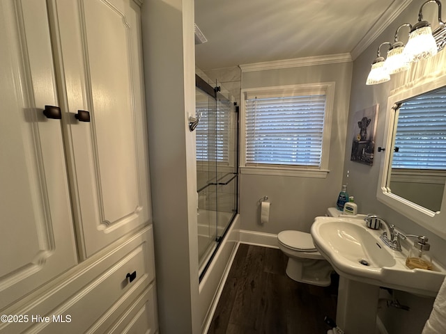 bathroom with bath / shower combo with glass door, ornamental molding, toilet, and hardwood / wood-style floors