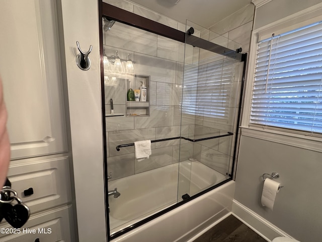 bathroom featuring enclosed tub / shower combo and hardwood / wood-style floors