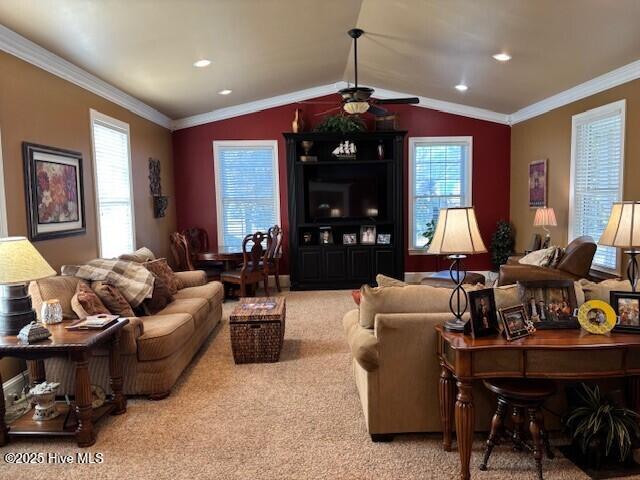 carpeted living room with vaulted ceiling, ceiling fan, and crown molding