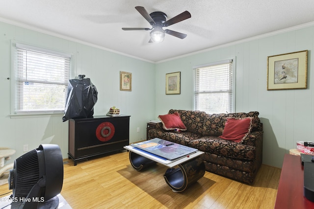 living room featuring light hardwood / wood-style floors, a wealth of natural light, and crown molding