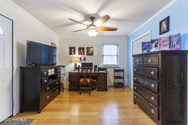 home office with light wood-type flooring, ceiling fan, ornamental molding, and a textured ceiling