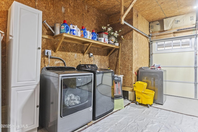 washroom featuring cabinets and washer and clothes dryer