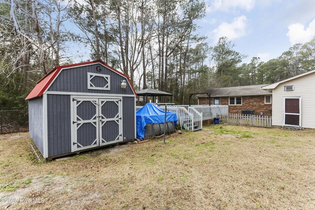 view of yard with a pool, a storage shed, and a gazebo