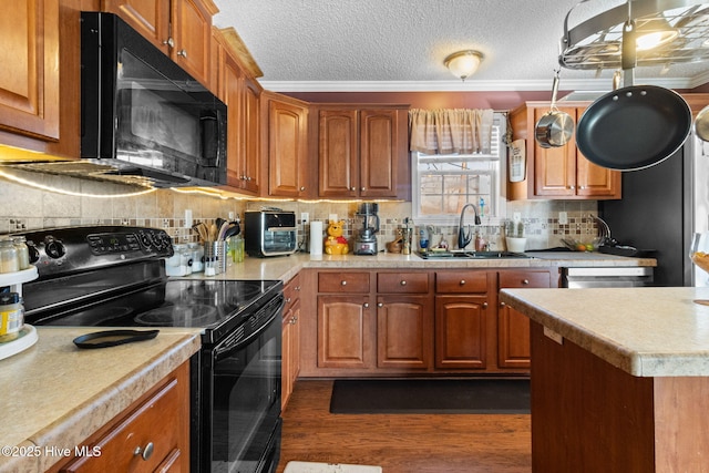 kitchen featuring dark wood-type flooring, sink, black appliances, ornamental molding, and backsplash