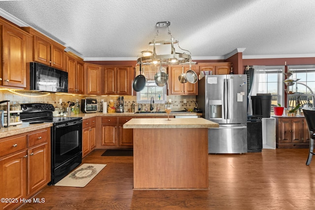 kitchen featuring sink, dark hardwood / wood-style floors, black appliances, a textured ceiling, and a kitchen island