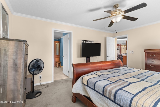 carpeted bedroom featuring a textured ceiling, ornamental molding, and ceiling fan