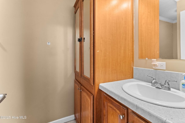 bathroom with crown molding, vanity, and backsplash