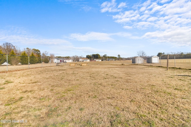 view of yard with a rural view and a shed