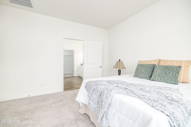 bedroom featuring a walk in closet and carpet floors