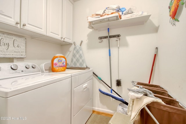 clothes washing area featuring cabinets and washer and clothes dryer