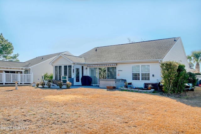 back of house featuring a hot tub and a patio