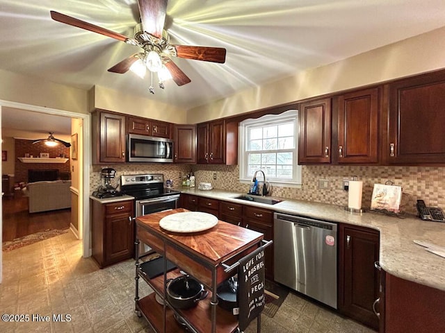 kitchen featuring dark brown cabinetry, sink, appliances with stainless steel finishes, ceiling fan, and backsplash