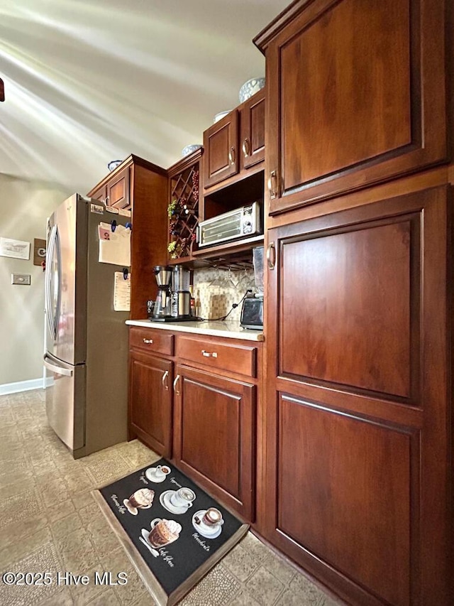 kitchen featuring decorative backsplash and stainless steel refrigerator