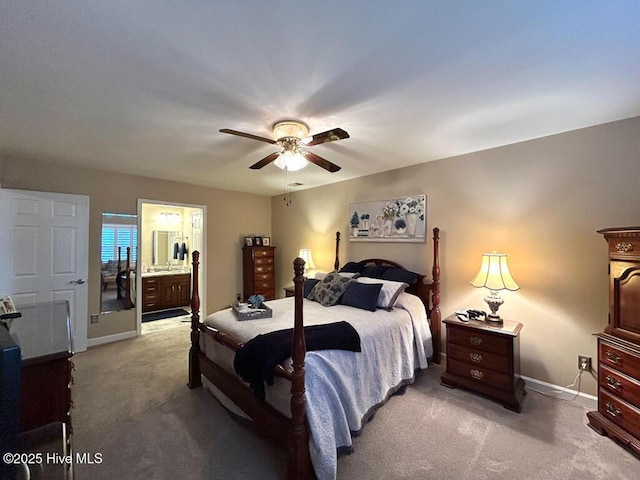 bedroom featuring ceiling fan, light carpet, and ensuite bath