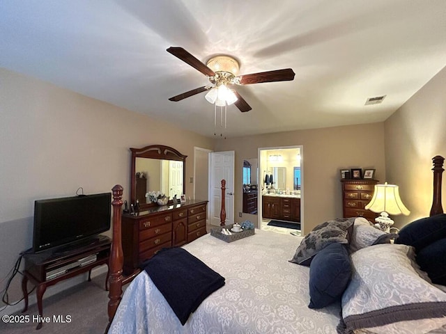 carpeted bedroom featuring ceiling fan and ensuite bath