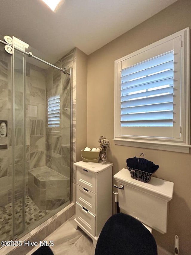 bathroom featuring an enclosed shower and toilet