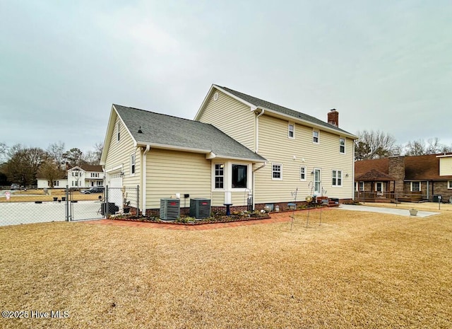 back of house featuring cooling unit and a lawn