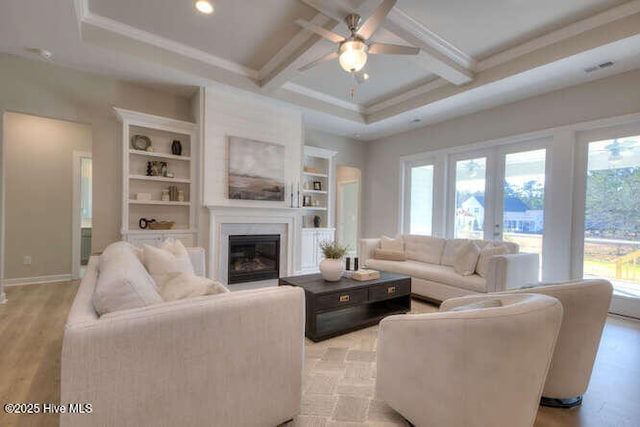 living room with a healthy amount of sunlight, coffered ceiling, beam ceiling, and light hardwood / wood-style flooring