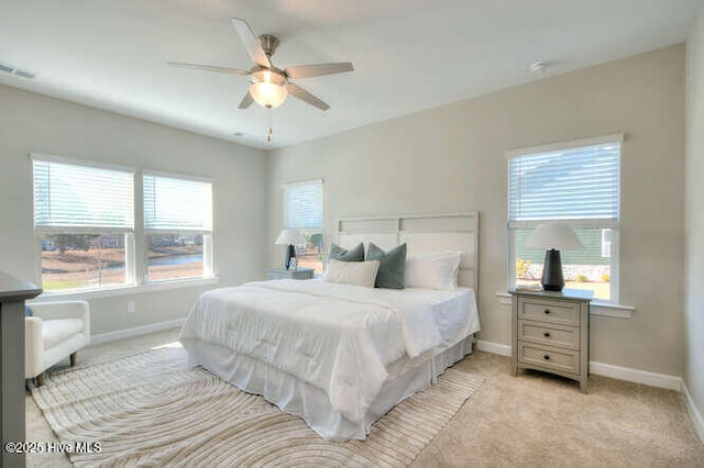 carpeted bedroom with multiple windows and ceiling fan