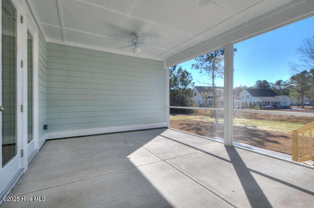 unfurnished sunroom featuring ceiling fan