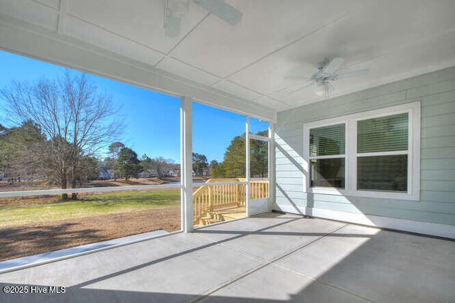 unfurnished sunroom with ceiling fan