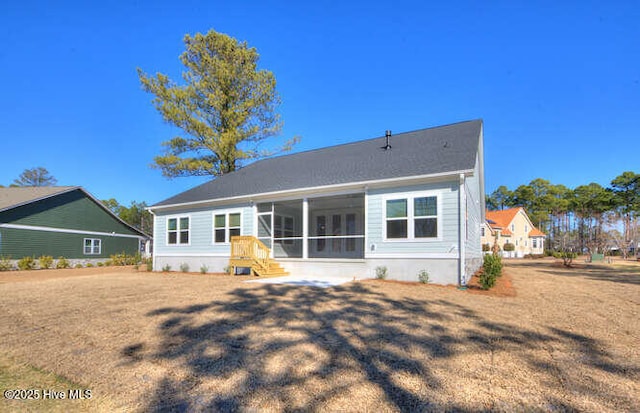 rear view of house featuring a lawn and a sunroom