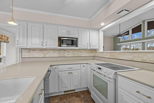 kitchen featuring tasteful backsplash, white cabinetry, hanging light fixtures, stainless steel appliances, and a textured ceiling