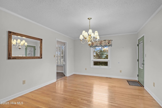 unfurnished dining area with crown molding, a textured ceiling, a chandelier, and light hardwood / wood-style floors