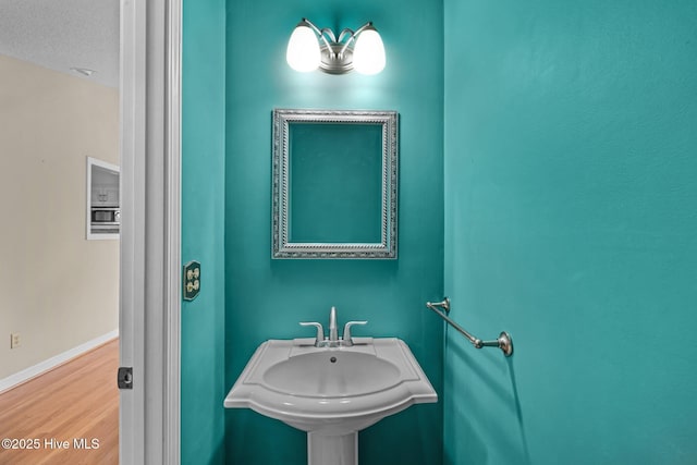 bathroom featuring wood-type flooring, sink, and a textured ceiling