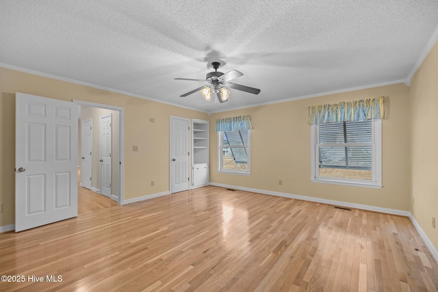 spare room with ceiling fan, crown molding, light hardwood / wood-style floors, and a textured ceiling