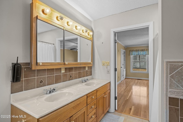 bathroom featuring tasteful backsplash, vanity, tile patterned flooring, and a textured ceiling