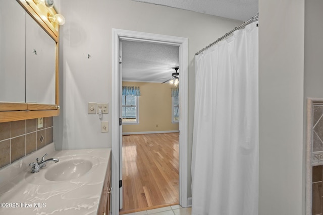 bathroom with tile patterned flooring, vanity, ceiling fan, and a textured ceiling