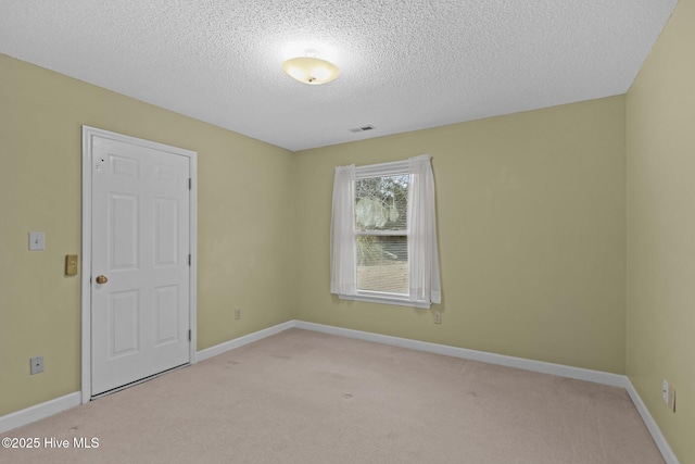 carpeted empty room with a textured ceiling