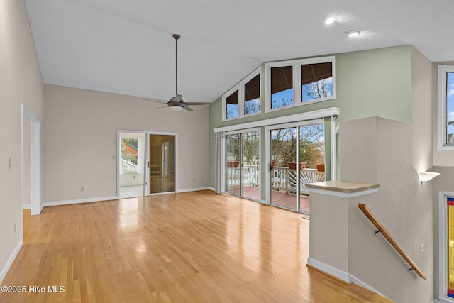 unfurnished living room featuring high vaulted ceiling, light hardwood / wood-style floors, and ceiling fan