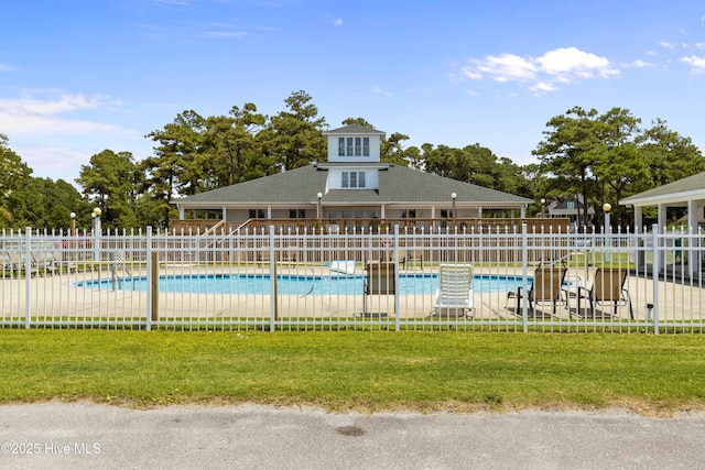 community pool with fence and a lawn