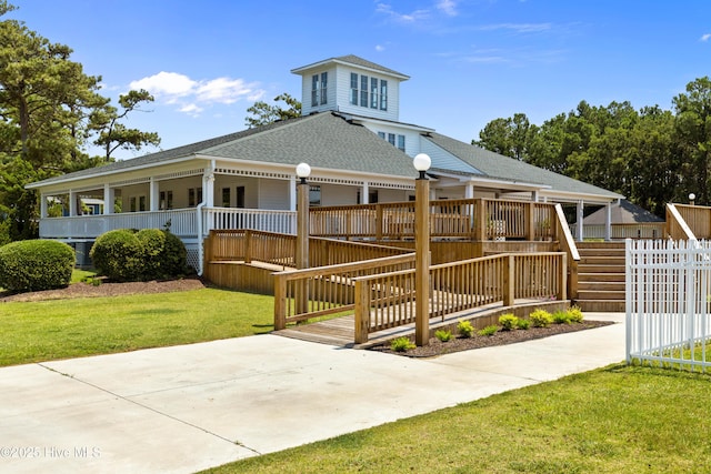 view of front of home featuring a shingled roof, a front yard, fence, and a wooden deck