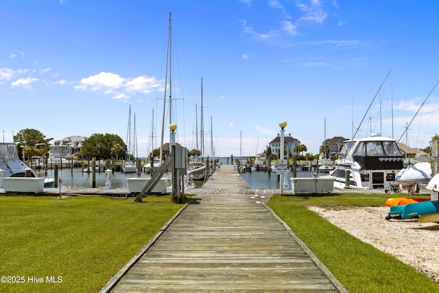 view of dock featuring a lawn and a water view