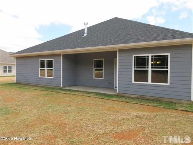 rear view of property with a patio and a lawn