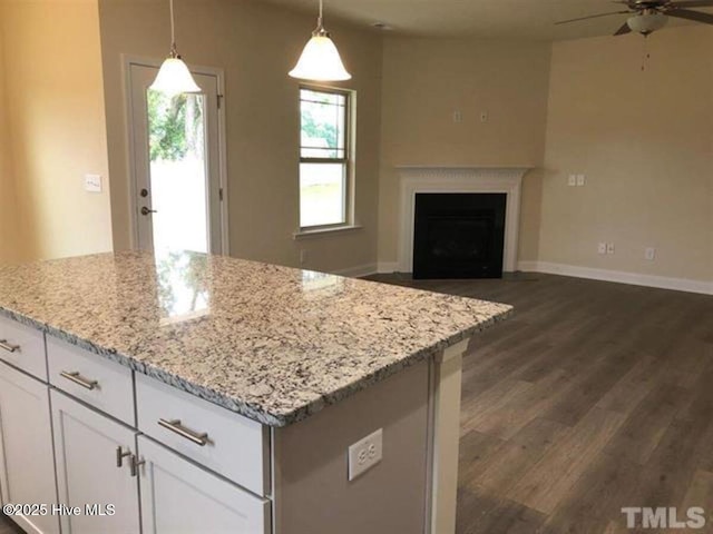 kitchen featuring dark hardwood / wood-style floors, white cabinetry, hanging light fixtures, ceiling fan, and light stone countertops