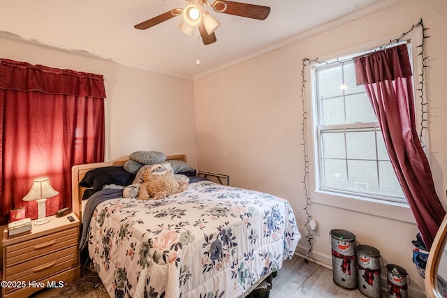 bedroom with multiple windows, wood-type flooring, crown molding, and ceiling fan