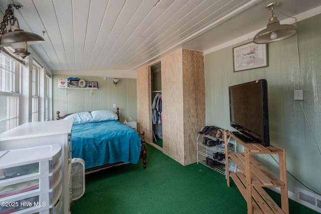 bedroom featuring dark carpet and wood walls