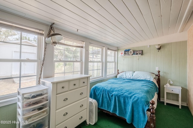 carpeted bedroom featuring wooden ceiling and wood walls